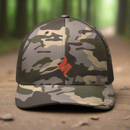 Camouflage baseball cap with a red logo on a metallic surface