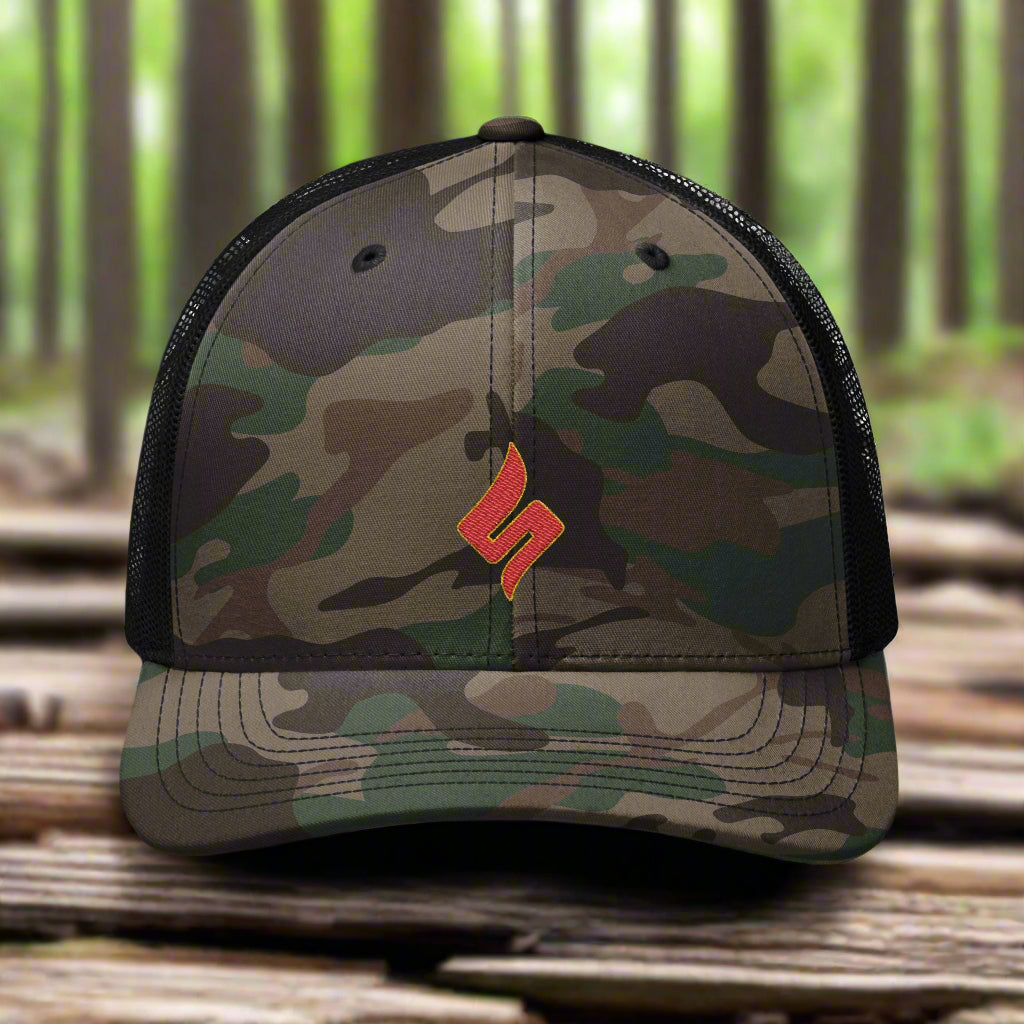 Camouflage cap with a red logo on a metallic surface