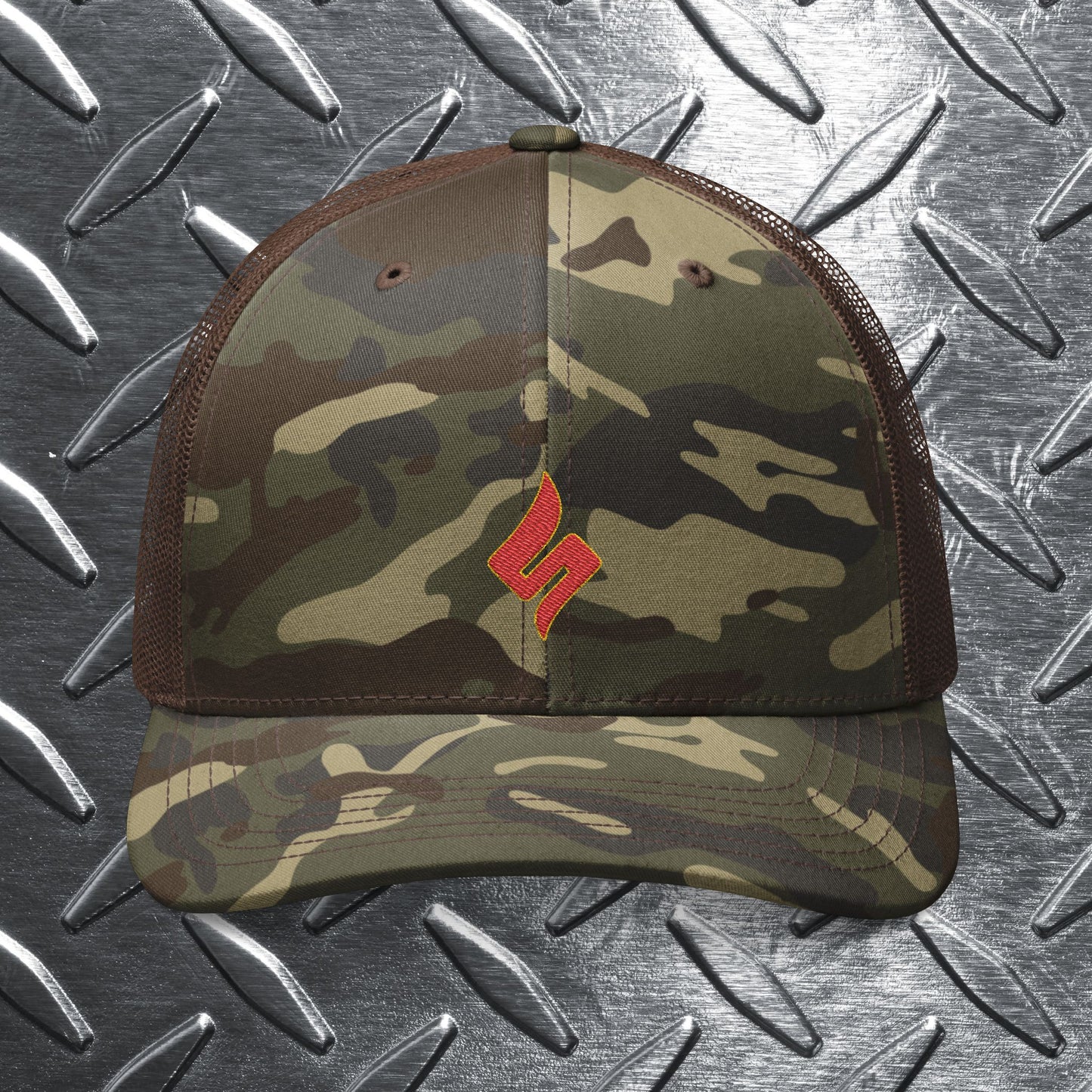 Camouflage baseball cap with a red logo on a metallic surface